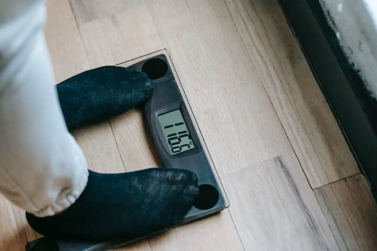 uma pessoa em cima de uma balança avaliando como perder 1kg em 1 semana